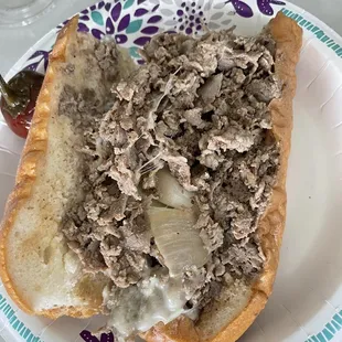 Half of a Philly cheesesteak (with provolone cheese and fried onions)