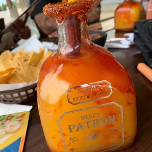 a bottle of hot sauce with a straw