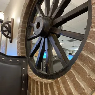 a large wheel on a brick wall