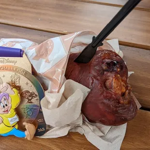 a ham wrapped in brown paper with a knife sticking out of it