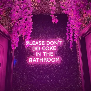 a neon sign that says please don't do coke in the bathroom