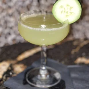 a cucumber cocktail in a coupe glass