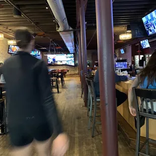 a blurry image of a woman walking through a restaurant