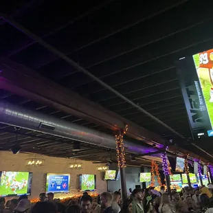 a large crowd of people watching televisions