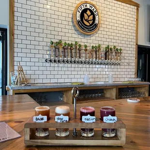 a row of beer glasses on a wooden table
