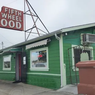 a green building with a neon sign