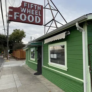 a green building with a neon sign