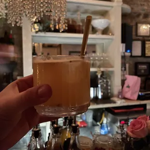 a person holding a glass of coffee