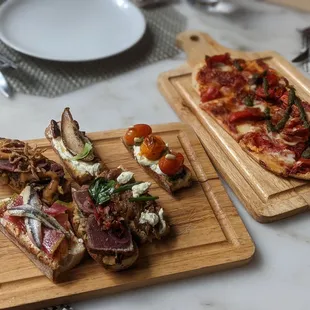 two wooden trays of food on a table