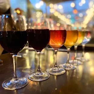 a row of wine glasses on a bar