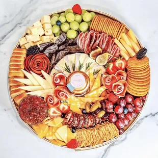 a platter of cheese, crackers, crackers, and fruit