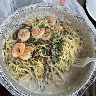 a plate of pasta with shrimp and mushrooms