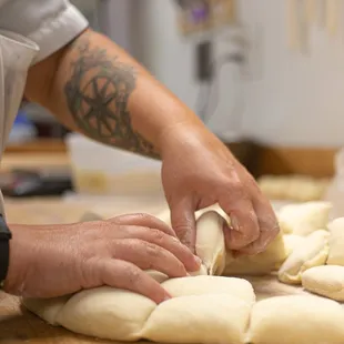 a chef kning bread dough on a wooden table