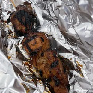 two pieces of chicken wrapped in tin foil