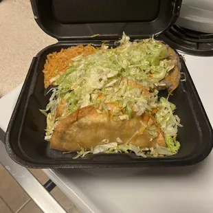 a black tray with a taco and rice