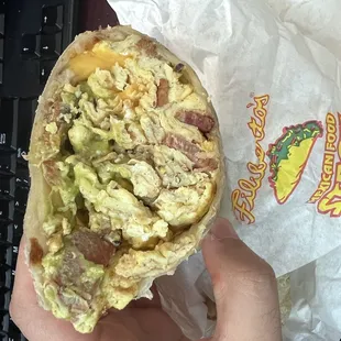 a hand holding a burrito