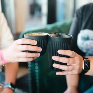wo people holding cups of coffee