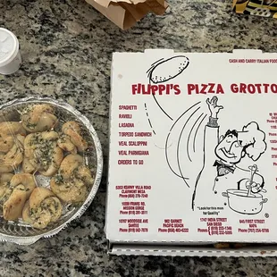 a box of filippi's pizza grotto and a bowl of
