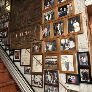 a staircase with a wall full of pictures