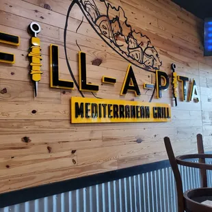 a wooden wall with a sign that says fill a pita