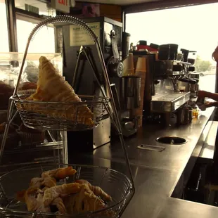 barista hard at work, pastries in the foreground