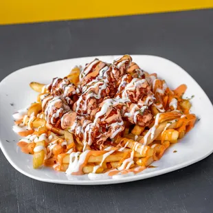 a plate of french fries covered in sauce