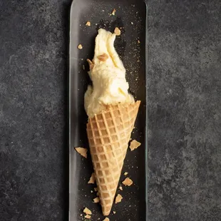 an ice cream cone on a black plate