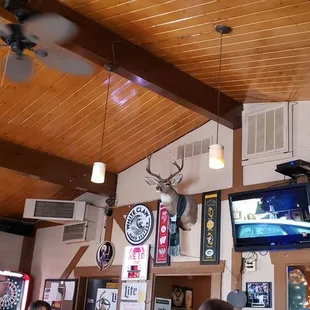 a man sitting at a bar watching televisions