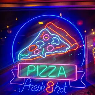 a slice of pizza in a neon sign