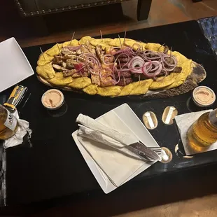 The platters share marinated chicken steak yeah, fried cheese and salami with pickled onions and Tostones