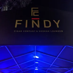 Entranceway to Findy Cigar Company with patio to the left and right.