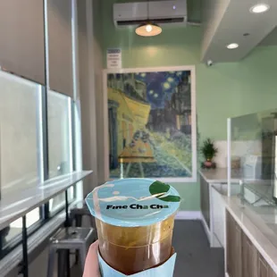 a hand holding a cup of coffee