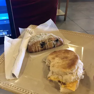 Bacon, egg, and cheese biscuit and a blueberry scone.