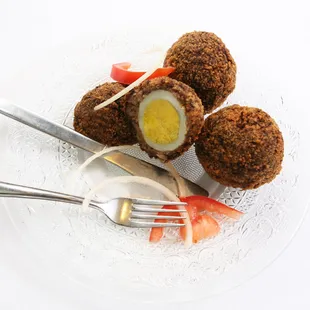 scotch Egg- hard boiled egg wrapped in sausage, rolled in bread crumb and then deep fried.