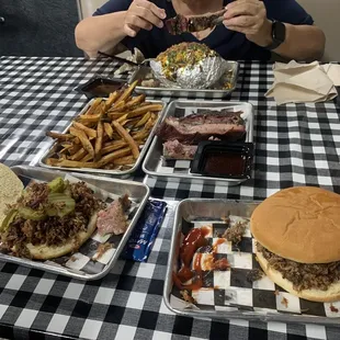 a woman eating a hamburger and fries