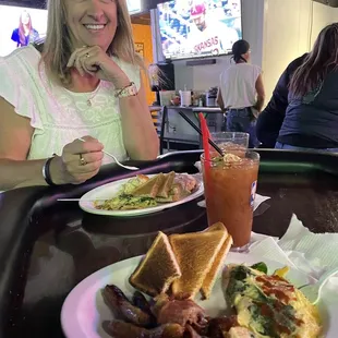 a woman sitting at a table with a plate of food