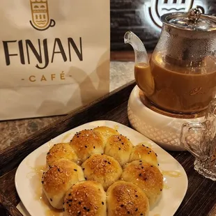 a plate of buns and a cup of coffee