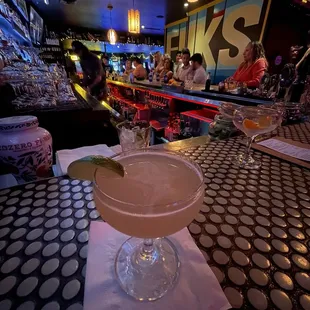 two cocktails on a table at a bar