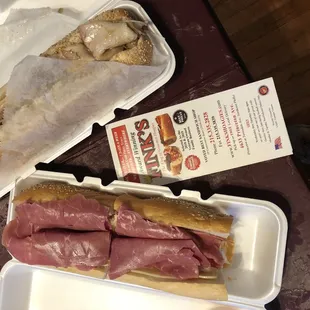 a sandwich in a styrofoam container and a sandwich in a styrofoam container