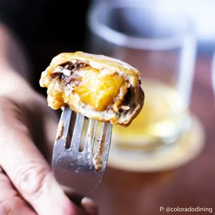 a person holding a fork with a pastry on it