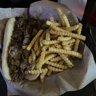 Philly sandwich with sautéed mushrooms and onions, served with generous portion of french fries. The shaved beef was very tender!