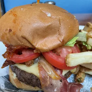 a hamburger and french fries on a newspaper
