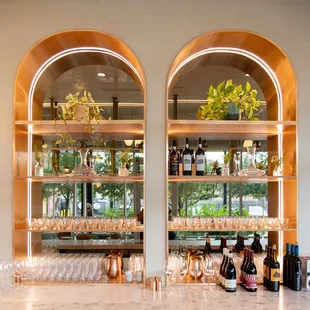 a bar with wine glasses and bottles