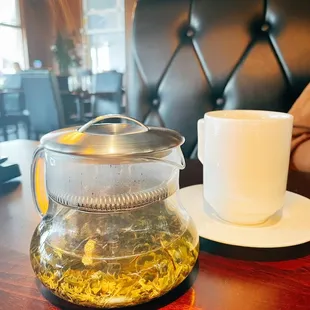  cup of tea and a teapot on a table