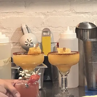 two glasses of cocktail on a counter