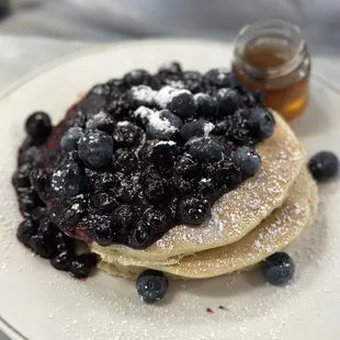 a stack of pancakes with blueberries and powdered sugar