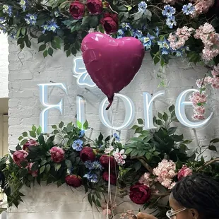 a woman sitting at a table with a heart shaped balloon