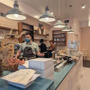 a man wearing a face mask behind a counter