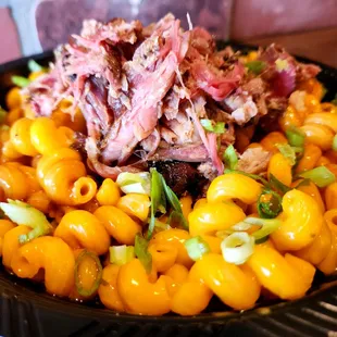 Huli Huli Mac has slow smoked pork, Hawaiian Huli Huli sauce and green onions on garlic parmesan cheddar mac