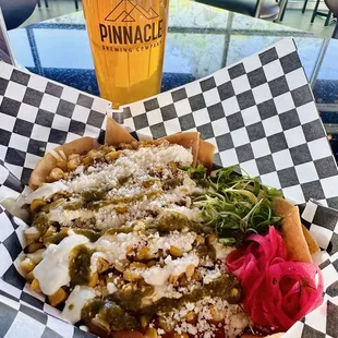 Street Corn Nachos. Crispy corn tortilla chips, with chargrilled corn fresh off the cob, beef chorizo beans, crema, cotija, poblano salsa.